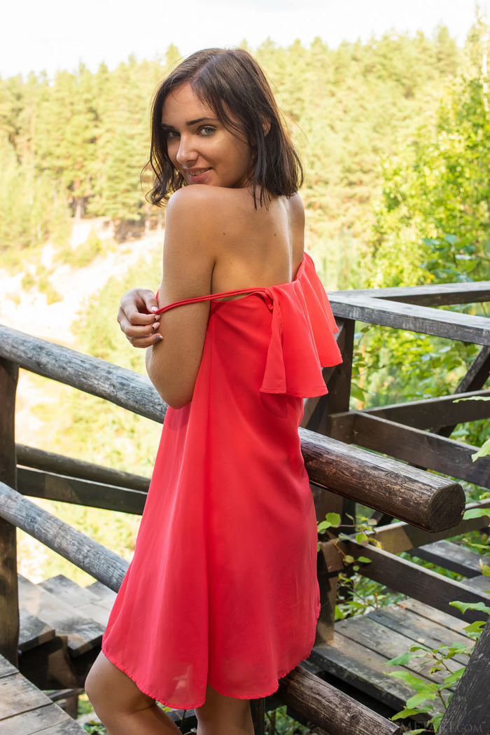Sexy brunette Oxana Chic slips off her white lace panties outdoors, for an upskirt peek at her lightly furred pussy